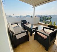 A spacious terrace of a family house with a view in Ynai Boğaziçi, with comfortable rattan seating.