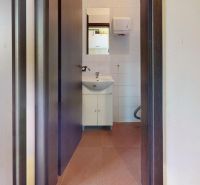 A sink with a ceramic cabinet in commercial premises, a room with white walls.