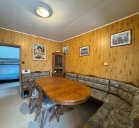 Dining area in a family house with a wooden decor floor and rustic furniture.
