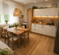 A kitchen in a family house with a dining table and a wooden-patterned floor.