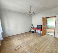 A room in a family house with a wooden decor floor, a television on the table.