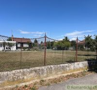 A plot with an older house and trees in the gardens of Bernolákovo under the blue sky.