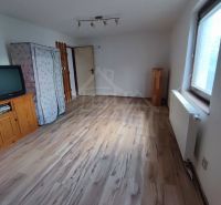 A room in a family house with a television and a wooden decor floor.