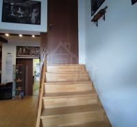 Staircase with a wooden decor floor and art paintings on the walls in a family house.