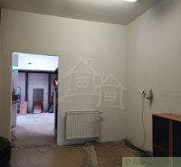 Interior of a family house with white walls, a radiator, and open doors.