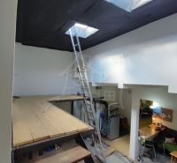 Attic with a ladder and a floor with wooden decor in a family house.