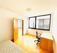 A room in a 4-room apartment with a wooden decor floor, a desk, and a chair.