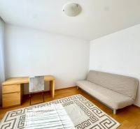 A room with a light sofa, a desk, and a wooden decor floor in a 4-room apartment.