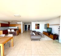 A spacious living room in a 4-room apartment with a kitchen, tiles, and comfortable seating.