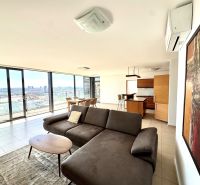 A spacious living area in a 4-room apartment with large windows and a view of the city.