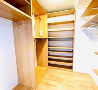 A wardrobe with shelves and a floor with a wood decor in a 4-room apartment.