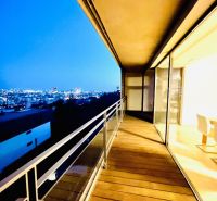 Night view from the balcony of a 4-room apartment with a wooden decor floor.