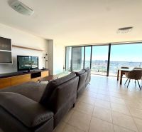 Bright living room with a sofa, TV, and large windows, 4-room apartment.