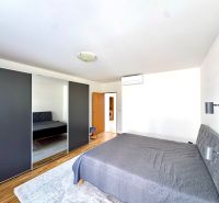 Bedroom in a 4-room apartment with a large wardrobe and a wooden decor floor.