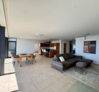 A spacious living room in a 4-room apartment with large windows, a sofa, and a dining table.