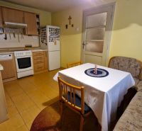 A kitchen in a family house with a kitchen unit, a corner bench, and a table with chairs.