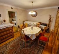 Dining room in a family house with wooden decor, table, and sideboard.