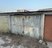 Abandoned garages in Bratislava - Nové Mesto with peeling plaster and metal doors.