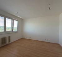 A room in a 2-room apartment with a wooden decor floor and a view from the window.