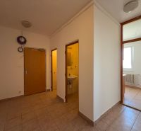 Interior of a 2-room apartment with tiles, bathroom on the left and room with a window on the right.