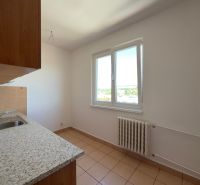 A kitchen in a 2-room apartment with a ceramic floor, simple cabinets, and a window with a view.