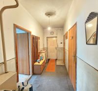Hallway in a family house with carpet, mirror, and entrance door.