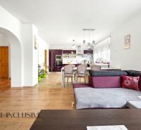 Interior of a family house with a kitchen, dining table, and wooden decor flooring.