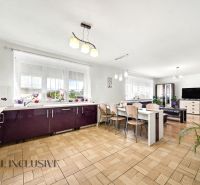 Spacious kitchen with dining area and wooden decor flooring in a family house.