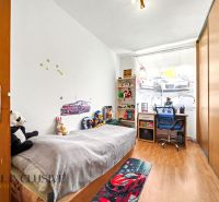 Children's room in a family house with toys, a bed, and a wooden decor floor.