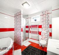 A bathroom in a family house with a bathtub, toilet, and shower.