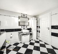 Bathroom in a family house with black and white tiles and a mirror above the sink.
