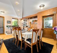 Dining room in a family house with a wooden decor floor and decorative flowers.