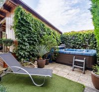 A family house garden with a deck chair, hot tub, and climbing plants on Majerská in Nová Dedinka.