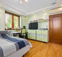 Children's room with a bed, desk, and floor with wooden decor in a family house.