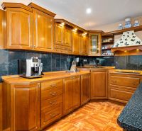 A kitchen in a family house with wooden cabinets and a floor with a wooden decor.