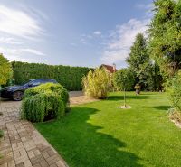 Garden at a family house on Majerská Street in Nová Dedinka. Elegant greenery and a car.
