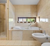 Bathroom in a family house with a bathtub, shower, and bidet.