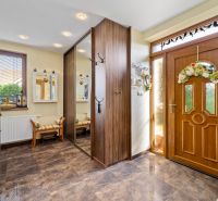 Entrance hall in a family house with a large mirror, wooden decor, and decorations.