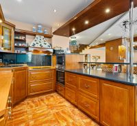 A kitchen in a family house with wooden cabinets and a floor with a wooden decor.
