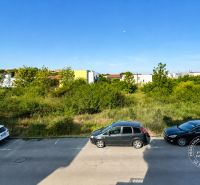 A road with cars on Vincent Šikula Street in the town of Stupava, surrounded by greenery.