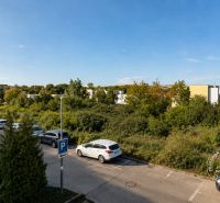Exterior on Vincenta Šikulu Street in Stupava, with a view of the parking lot and greenery, 2-room apartment.