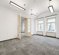 Offices with white walls, large windows, and carpeted floors.