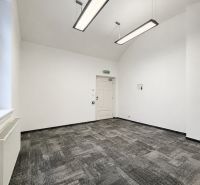Offices with carpeted floors and pendant lights in neutral colors.