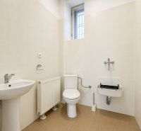 Office restroom with beige tiles and a sink.