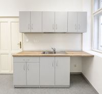 Gray kitchen unit with a wooden countertop in the office.