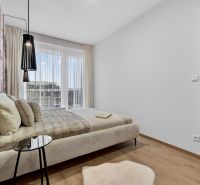 A bedroom with light furniture, a wooden decor floor, a large window, and a curtain.
