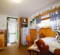 Interior of a cabin with wooden decor, traditional furniture, and a decorated window.
