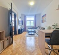 Living room with wood-patterned flooring, a sofa, and a desk in a 3-room apartment.