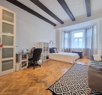 A bedroom in a 3-room apartment with a wooden decor floor and ceiling beams.