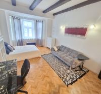 Partially furnished 3-room apartment with a sofa, table, and wooden decor flooring.